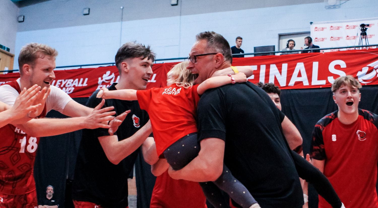 Coach Alex Porter and his daughter celebrate with the team