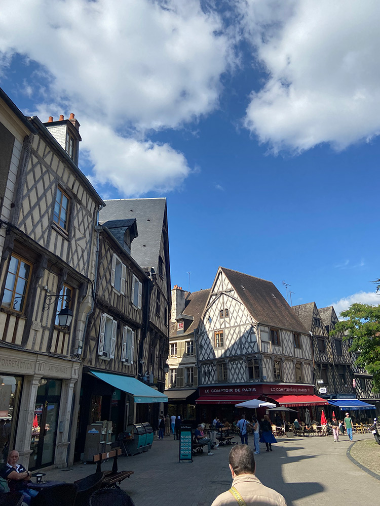 Image of a French village street with buildings, trees and people - image taken by student Eniola Abdul