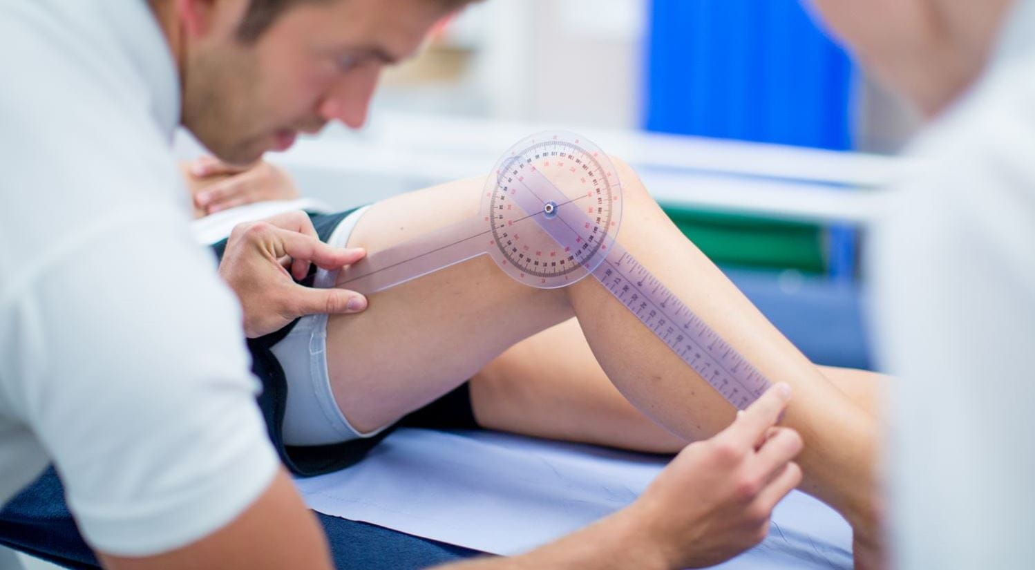 A Sports Therapy student measuring the angle of a patient's knee joint.