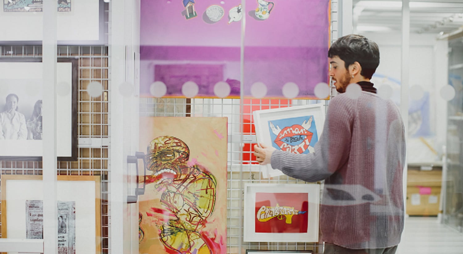 A student places a painting in the ESCALA collection
