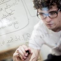 Student writing notes on glass in study spcae