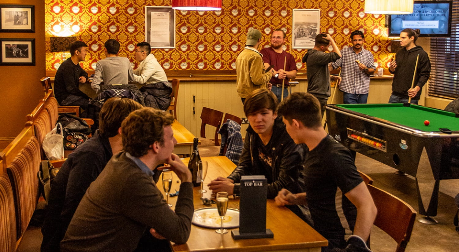 Students enjoy a drink and a game of pool in Top Bar