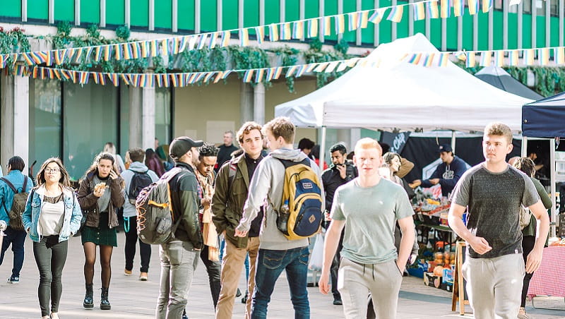 group of students walking across Colchester Campus squares